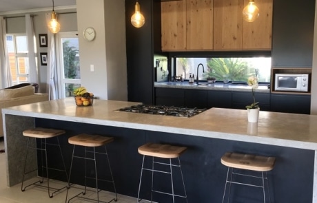 Modern kitchen with oversized island, timber cabinetry and integrated breakfast seating.