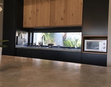 Black and timber kitchen cabinetry with integrated window splashback feature.