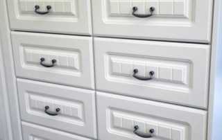 A white cabinet with multiple drawers and handles.