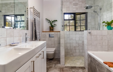 A modern bathroom with a shower area and a bathtub, featuring tiled walls and a double sink vanity
