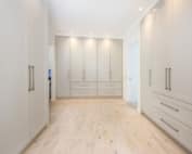 Spacious walk-in wardrobe with custom cabinetry and integrated drawer storage