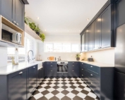 Navy shaker kitchen with checkered flooring and ample storage.