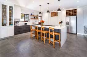 BATHROOM-CABINETS_Related-services2 Designer kitchen island with wooden bar stools and pendant lighting