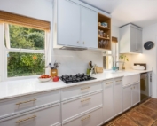 White shaker kitchen with gas hob and farmhouse sink