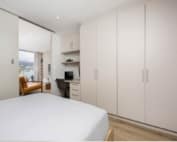 Bedroom with built-in wardrobes and integrated study workstation nook