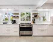 Classic white shaker kitchen with central freestanding oven and shelving