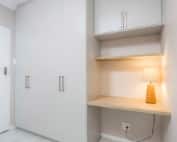 Built-in bedroom cupboards with integrated desk and overhead storage