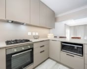 Modern beige kitchen with built-in oven and microwave station